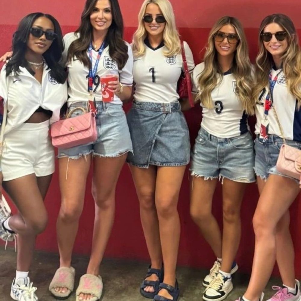 Englands Spielerfrauen Tolami Benson, Ellie Alderson, Megan Pickford, Anouska Santos und Dani Dyer posieren im England-Trikot für ein Foto.