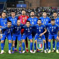Die italienische Nationalmannschaft posiert vor einem Spiel auf dem Rasen.
