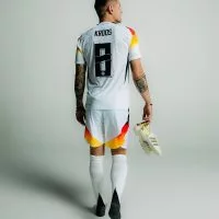 Toni Kroos im Deutschland-Trikot mit seinen Fußballschuhen in der Hand.